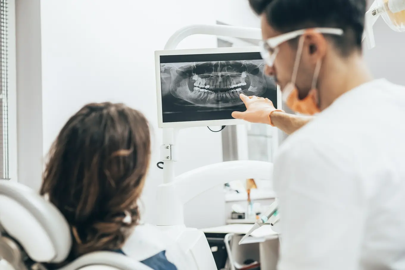 lekarz i pacjentka patrzą na prześwietlenie zębów